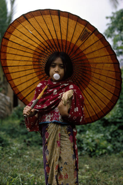 A Muslim girl in traditional dress blows a bubble with her gum. [Photo of the day - FEBRUARY 8, 2011]